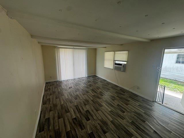 An empty room with wood-look flooring, a sliding glass door, and a window air conditioner — 7130 COMMONS BOULEVARD, PORT RICHEY, FL