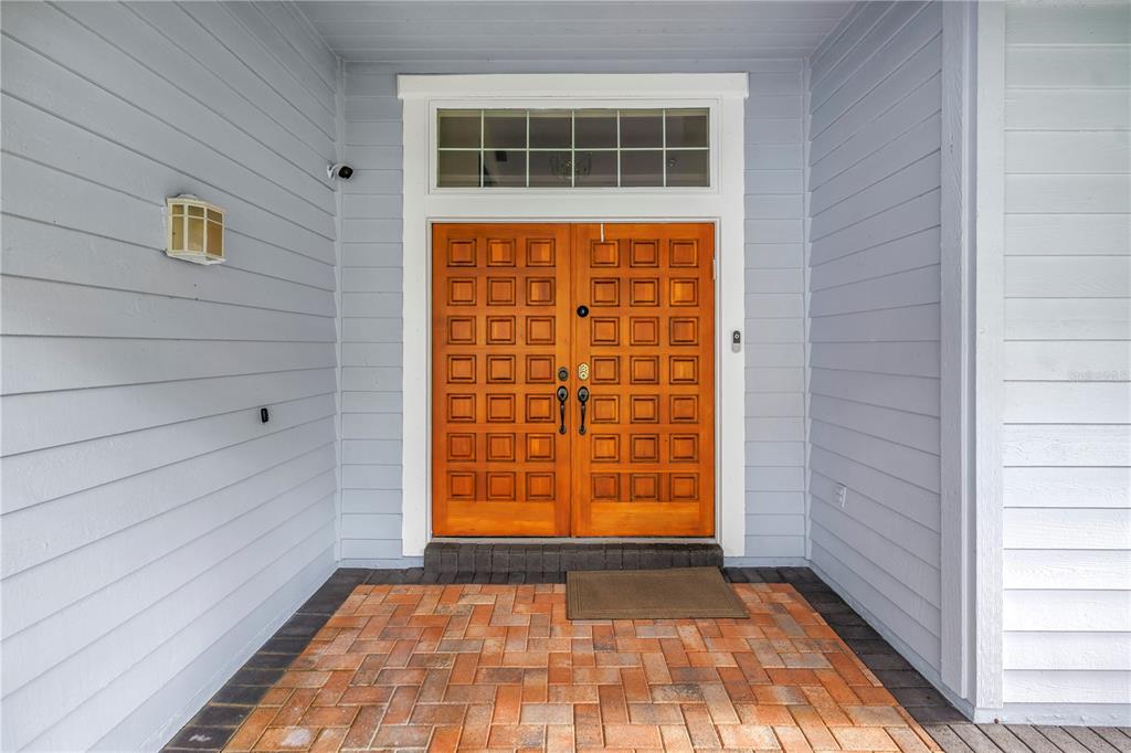 A front entryway features double wooden doors with square panels and a transom window above — 12383 WINDTREE BOULEVARD, SEMINOLE, FL