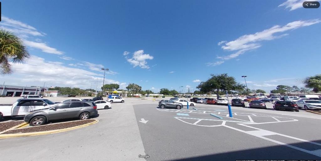 A large, paved parking lot filled with various parked cars under a bright blue sky — 3441 13TH ST ROAD, ST CLOUD, FL