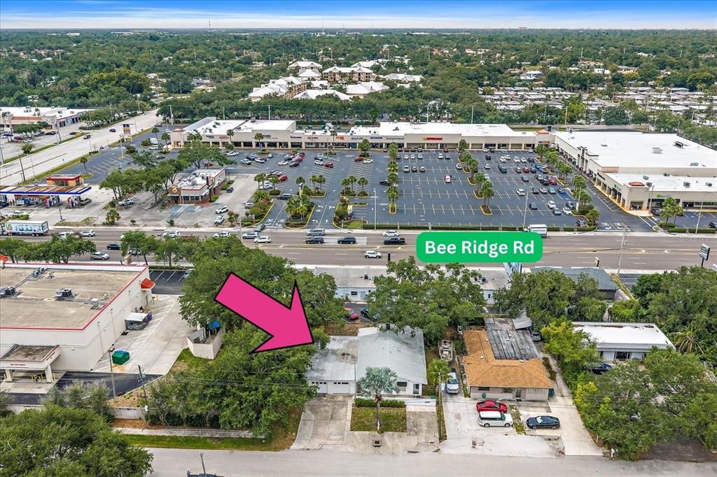 An aerial view shows a single-story house with a driveway located near a busy road — 4242 MCINTOSH LANE, SARASOTA, FL