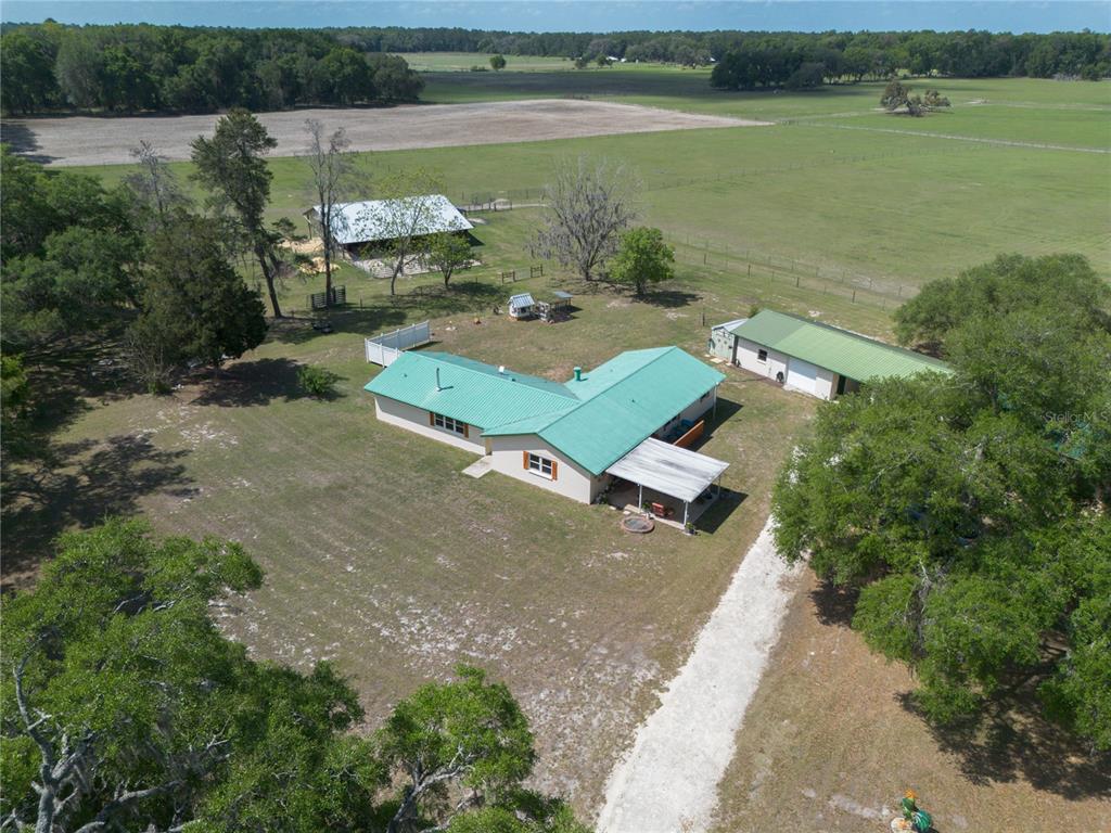 An aerial view shows a house with a green metal roof and a detached garage — 3019 SE 90TH AVENUE, NEWBERRY, FL