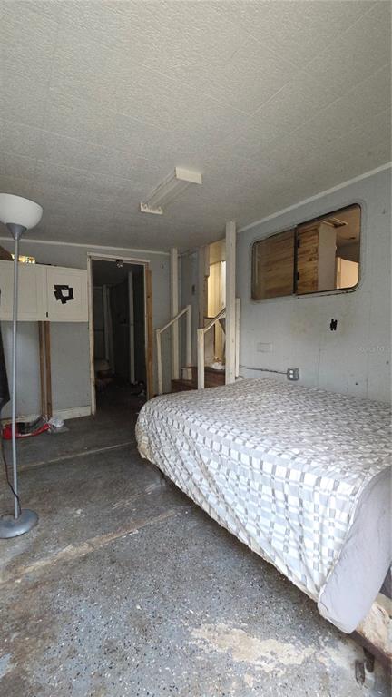 A bedroom with a bed, a floor lamp, and an interior window overlooking another room — 3000 CLARCONA ROAD UNIT 510, APOPKA, FL