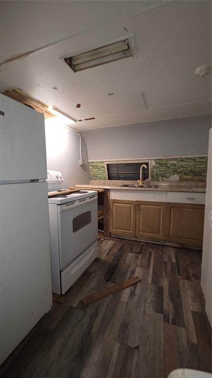 A kitchen features a white refrigerator, a white stove, wood cabinets, and wood-look flooring — 3000 CLARCONA ROAD UNIT 510, APOPKA, FL