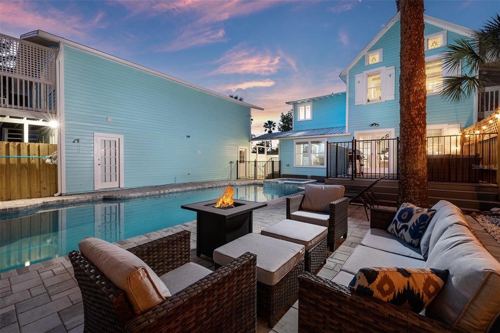 A backyard patio features a swimming pool, a fire pit, and outdoor wicker furniture — 551 OMAHA STREET, PALM HARBOR, FL