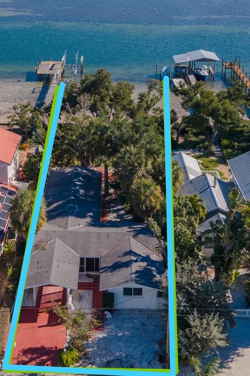 An aerial view shows a waterfront house with a private dock and boat lift — 2316 CANASTA DRIVE, BRADENTON BEACH, FL