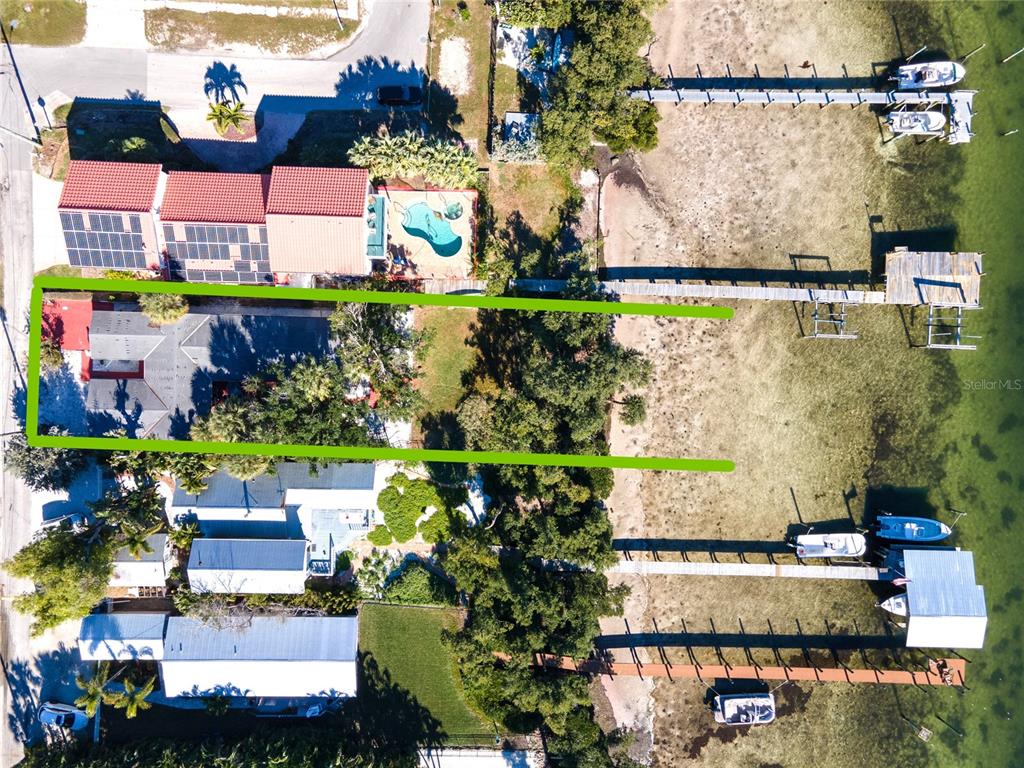 Aerial view of a waterfront property with a house, private dock, and surrounding vegetation — 2316 CANASTA DRIVE, BRADENTON BEACH, FL