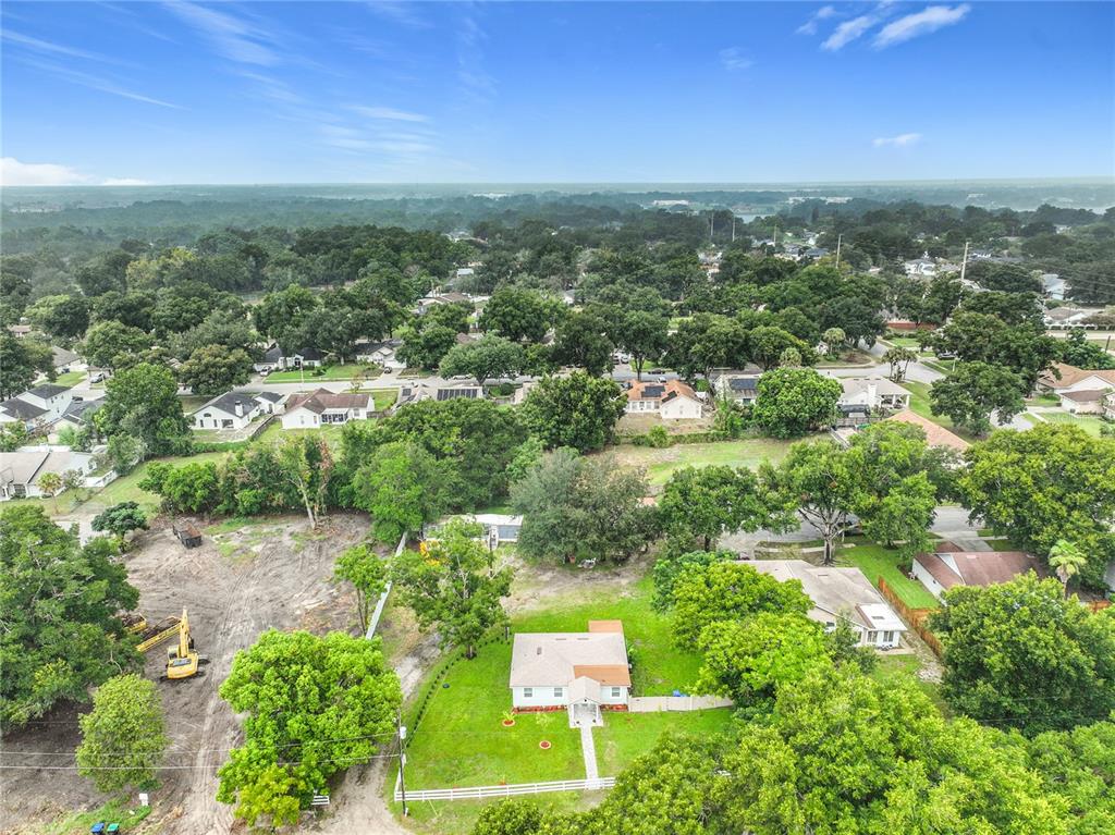 An aerial view shows a single-story house with a white fence on a large lot — 552 B C TERRY ROAD, OCOEE, FL