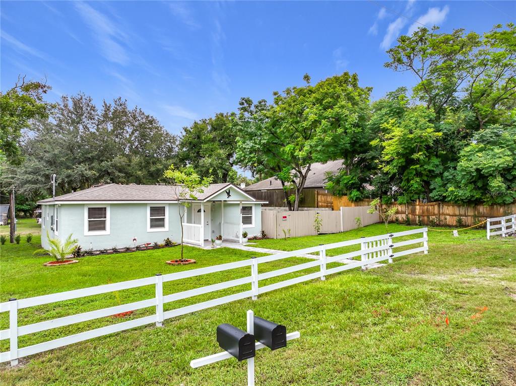 A light green house with a white fence and two mailboxes in the front yard — 552 B C TERRY ROAD, OCOEE, FL