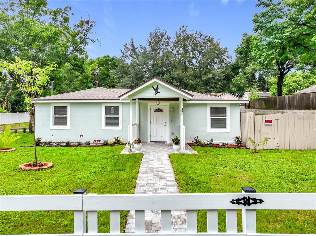 A light green single-story house with a white front door and a paved walkway — 552 B C TERRY ROAD, OCOEE, FL