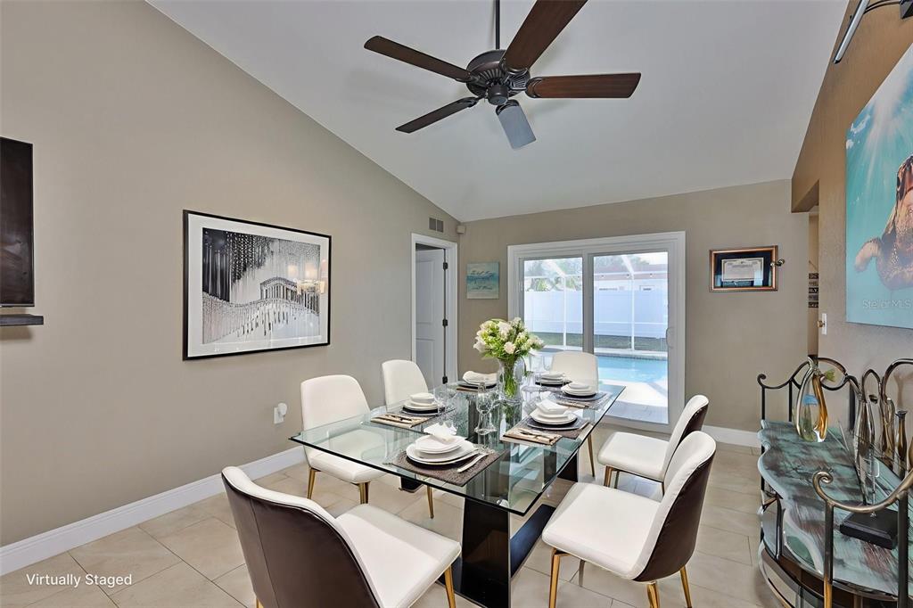 A dining room features a glass table, six chairs, a ceiling fan, and pool views — 9275 133RD STREET, SEMINOLE, FL