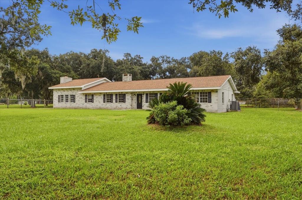 A single-story brick house with a shingled roof sits on a large, grassy lawn — 2925 MCGEE ROAD, PLANT CITY, FL