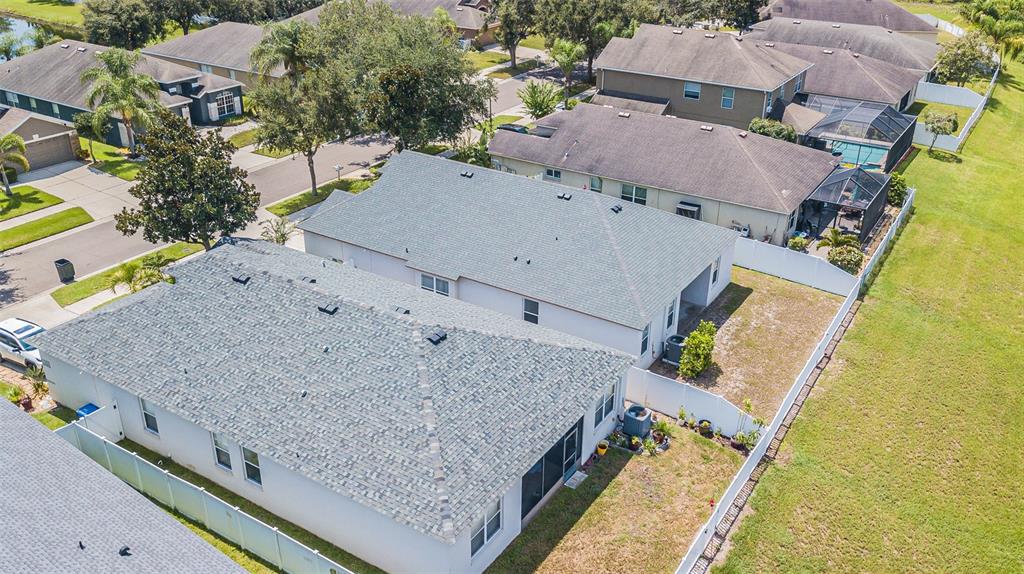 An aerial view shows suburban houses with gray shingled roofs and fenced backyards — 11345 FLORA SPRINGS DRIVE, RIVERVIEW, FL