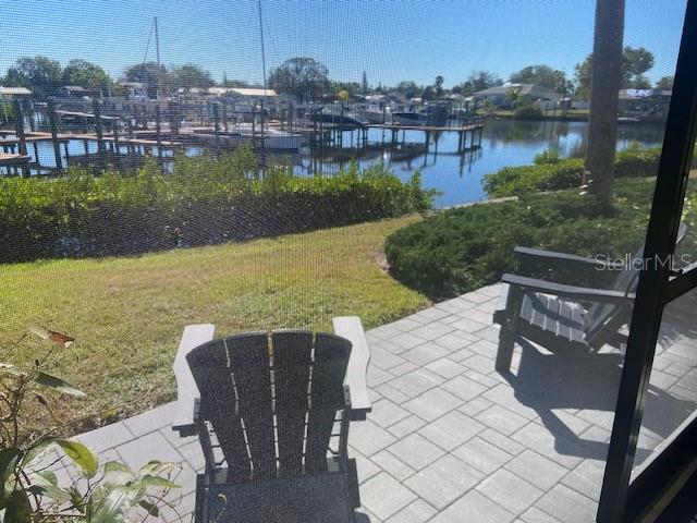A patio with two Adirondack chairs overlooks a canal with boat docks and watercraft — 646 YARDARM DRIVE UNIT 23, APOLLO BEACH, FL