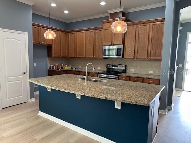 A kitchen features wood cabinets, granite countertops, a large island, and blue-painted walls — 16758 ABBEY HILL COURT, CLERMONT, FL