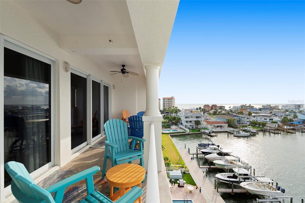 An aerial view shows multi-story waterfront condominiums with boat slips along a canal at sunset — 17717 GULF BOULEVARD UNIT 604, REDINGTON SHORES, FL