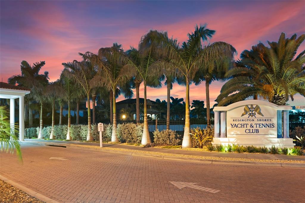 The entrance to the Redington Shores Yacht & Tennis Club features a paved driveway at sunset — 17717 GULF BOULEVARD UNIT 604, REDINGTON SHORES, FL