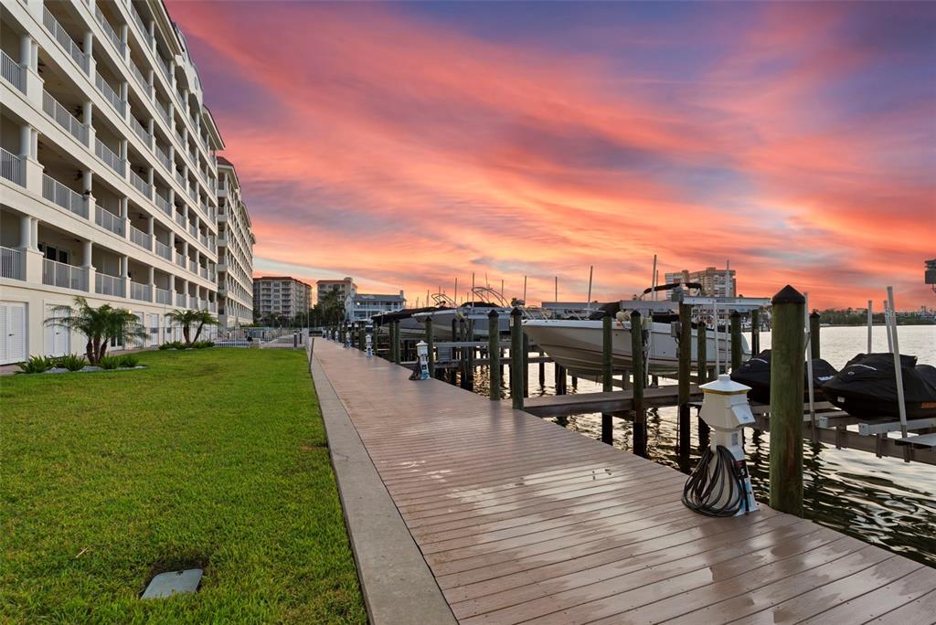 An aerial view shows a gated residential community with a tennis court and nearby waterfront — 17717 GULF BOULEVARD UNIT 604, REDINGTON SHORES, FL