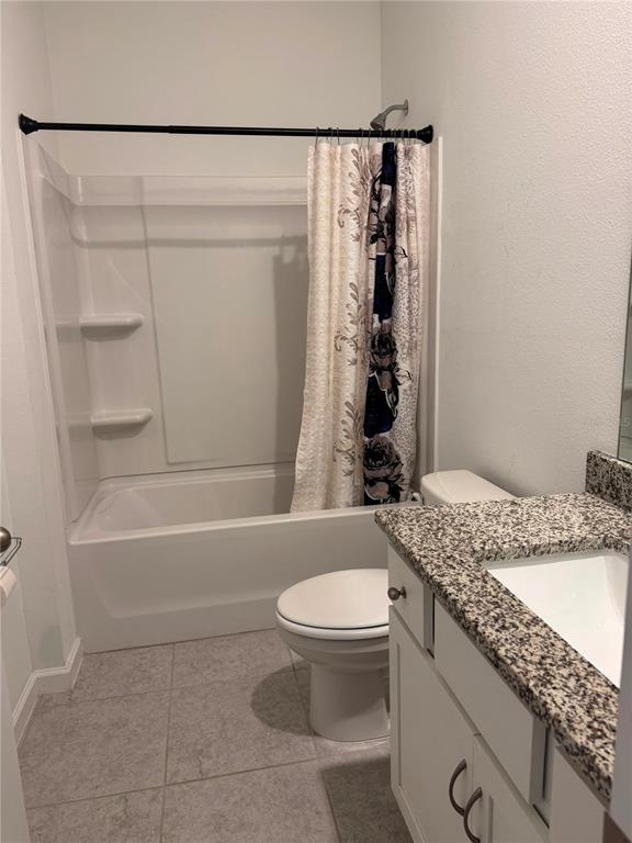 A bathroom features a white tub-shower combo, a toilet, and a granite-topped vanity — 1457 DALKEITH COVE, SANFORD, FL