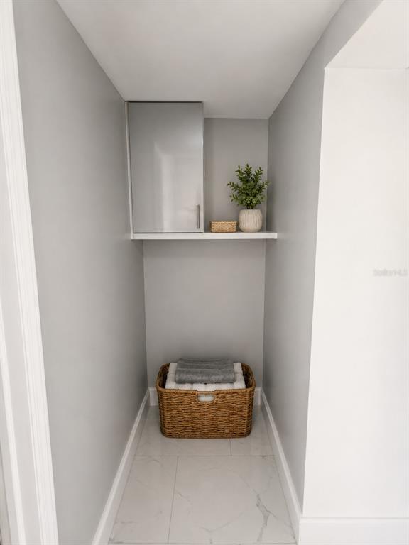A small alcove features a white shelf, a gray cabinet, and a woven basket with towels — 2630 SW 55TH AVENUE, WEST PARK, FL