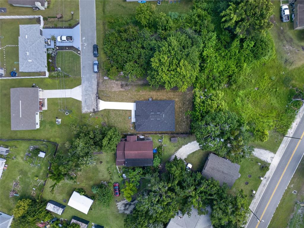 An aerial view shows a residential neighborhood with houses, driveways, and surrounding trees — 2225 MCCARTHY AVENUE, SANFORD, FL