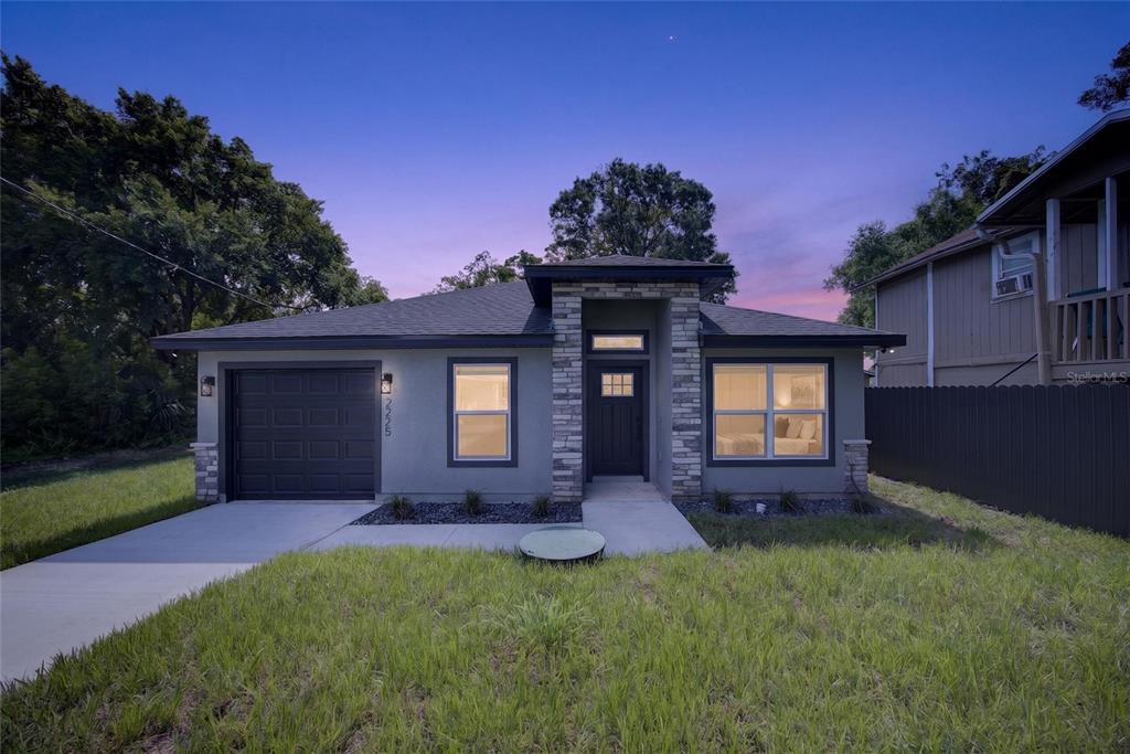 A single-story house with a gray stucco exterior, stone accents, and a one-car garage — 2225 MCCARTHY AVENUE, SANFORD, FL