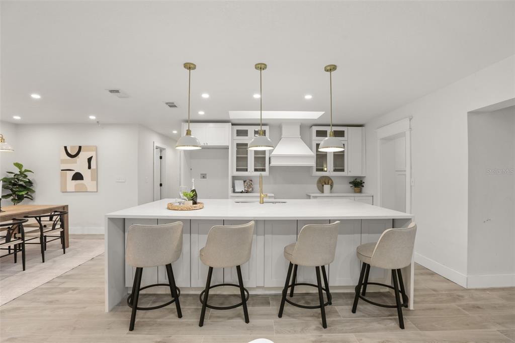 A living room features a long fireplace with slatted detailing, white cabinetry, and two armchairs — 724 MONMOUTH WAY, WINTER PARK, FL