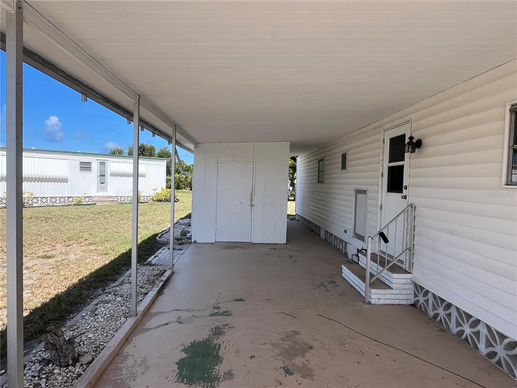 A covered carport area features a concrete floor, a storage shed, and a side entrance — 633 COMO DRIVE, VENICE, FL