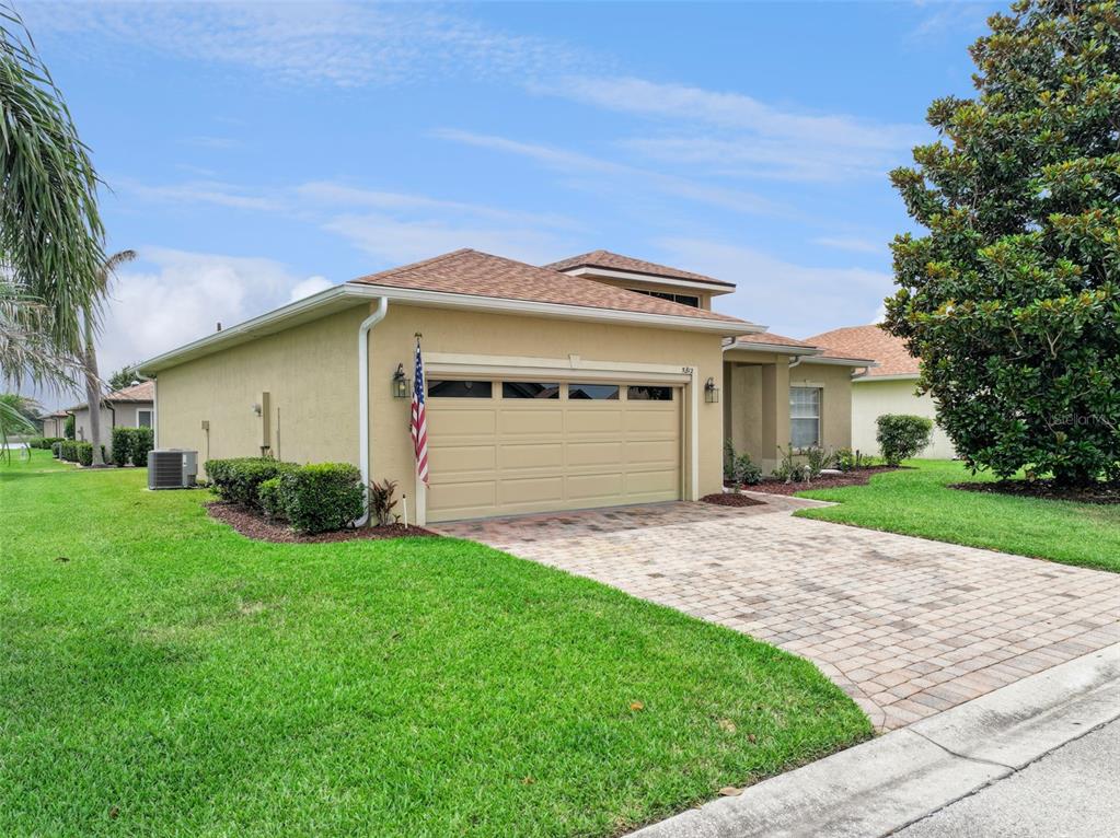 A tan single-story house with a two-car garage and a paved driveway — 5312 NICKLAUS DRIVE, WINTER HAVEN, FL