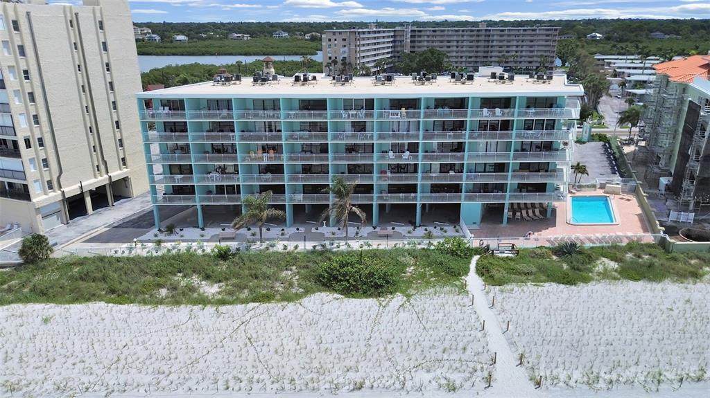 A view of a sandy beach and ocean from a balcony with a white railing — 19440 GULF BOULEVARD UNIT 104, INDIAN SHORES, FL