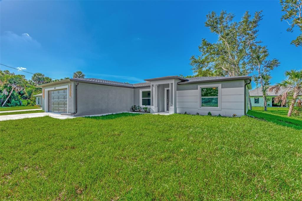 A single-story house with a gray exterior, a front-facing garage, and a green lawn — 3847 E PRICE BOULEVARD, NORTH PORT, FL