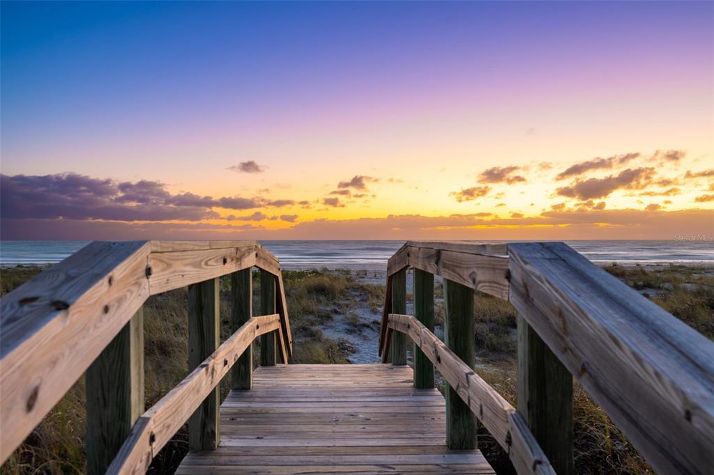 A wooden boardwalk leads through sand dunes toward the ocean at sunset — 7070 PLACIDA ROAD UNIT 1212, PLACIDA, FL