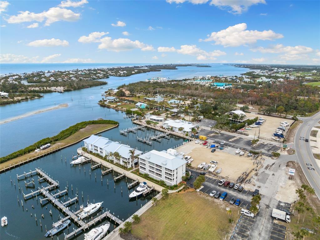 An aerial view shows a marina with docked boats and adjacent multi-story residential buildings — 7070 PLACIDA ROAD UNIT 1212, PLACIDA, FL