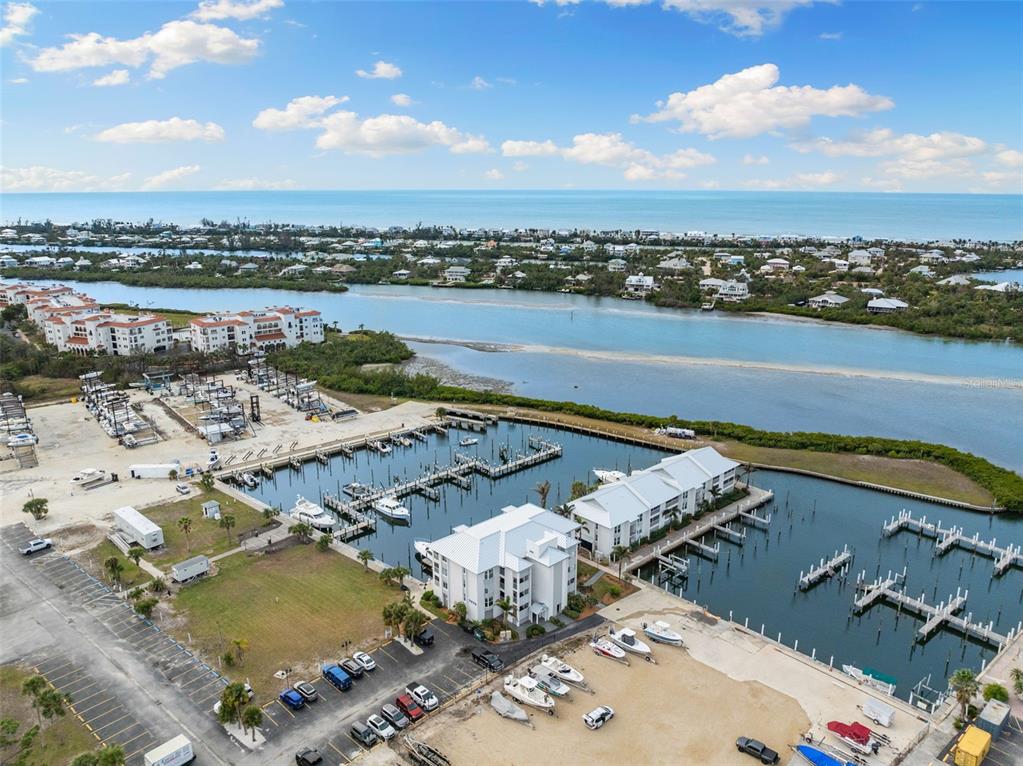 An aerial view shows a marina with boat slips, multi-story buildings, and a parking lot — 7070 PLACIDA ROAD UNIT 1212, PLACIDA, FL