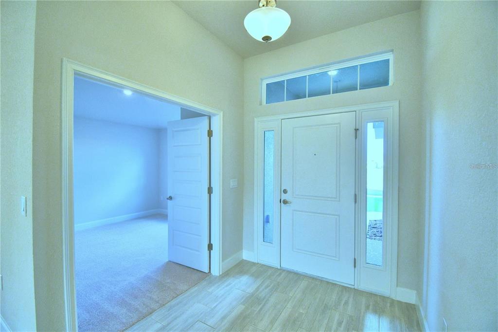 An entryway features tile flooring, a white front door with sidelights, and an adjacent room — 3639 LINDBERGH STREET, LAKELAND, FL