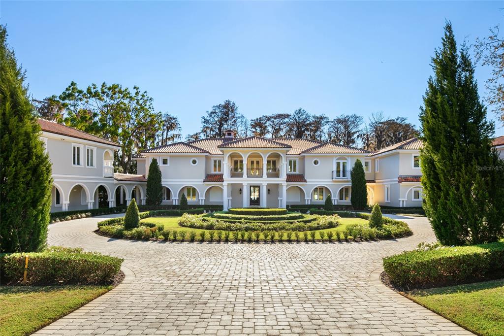A large two-story mansion with a circular driveway and manicured landscaping in front — 12488 PARK AVENUE, WINDERMERE, FL