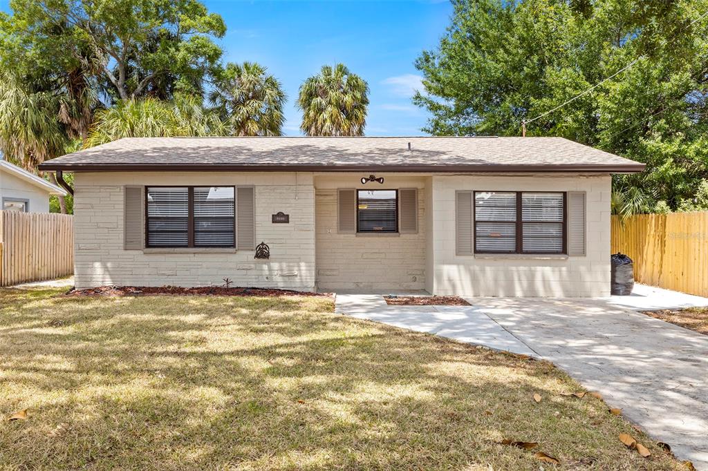A single-story house with a light-colored stone facade, brown shutters, and a concrete driveway — 2539 W UNION STREET, TAMPA, FL