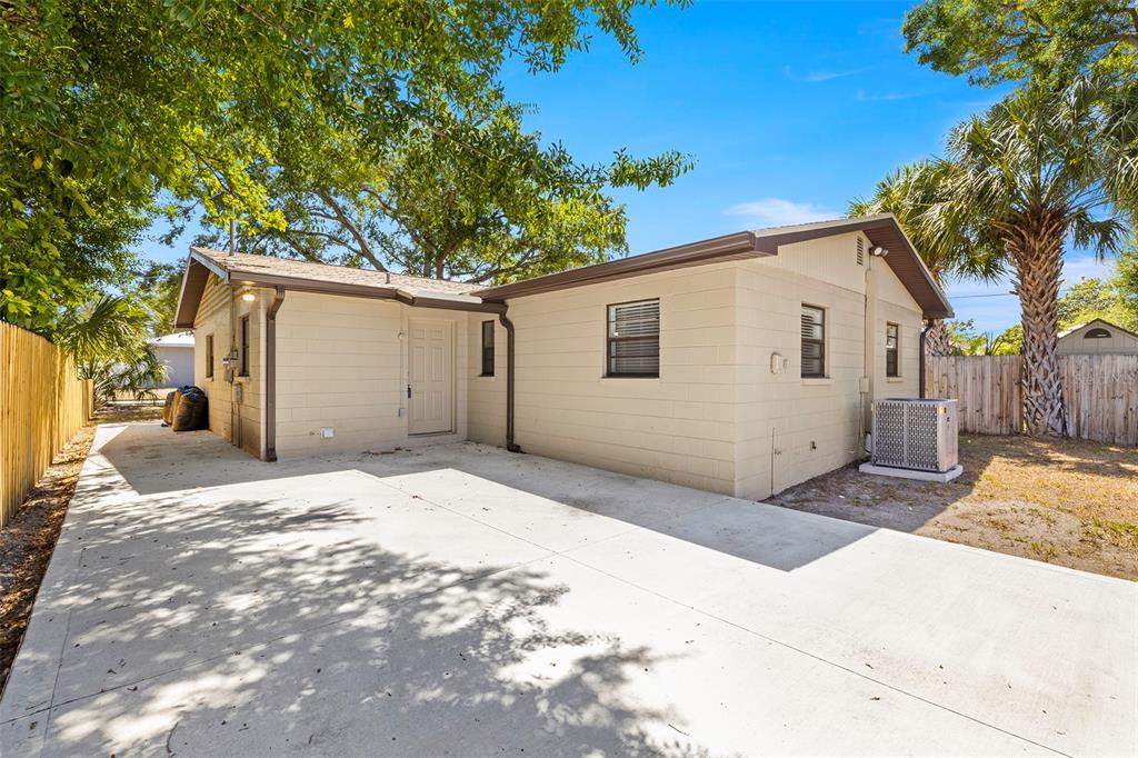 The exterior of a beige concrete block house with a concrete driveway and palm trees — 2539 W UNION STREET, TAMPA, FL
