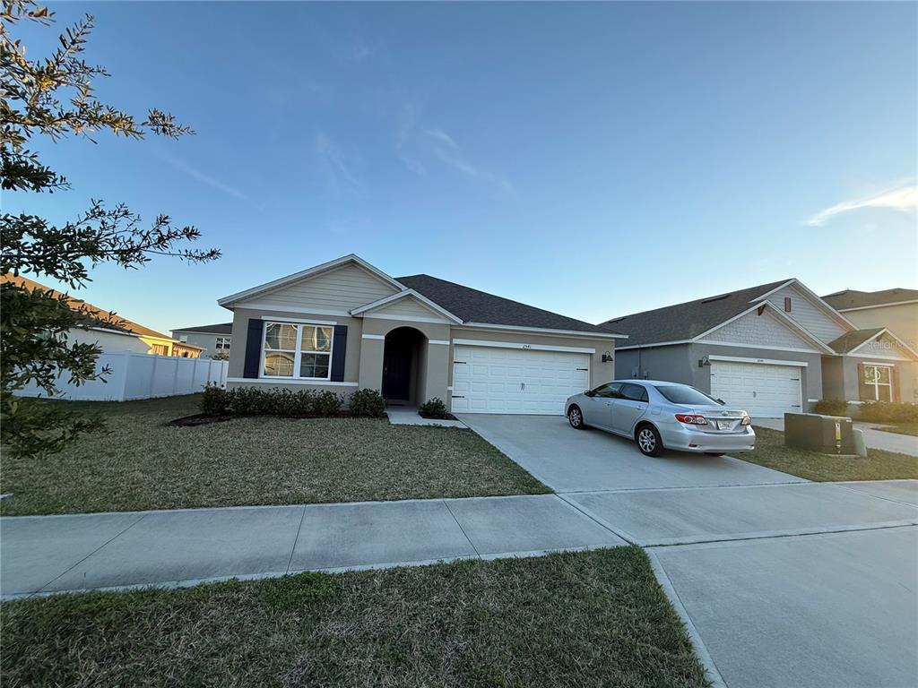 A single-story suburban house with a two-car garage and a concrete driveway — 2541 HARMONIA HAMMOCK ROAD, ST CLOUD, FL