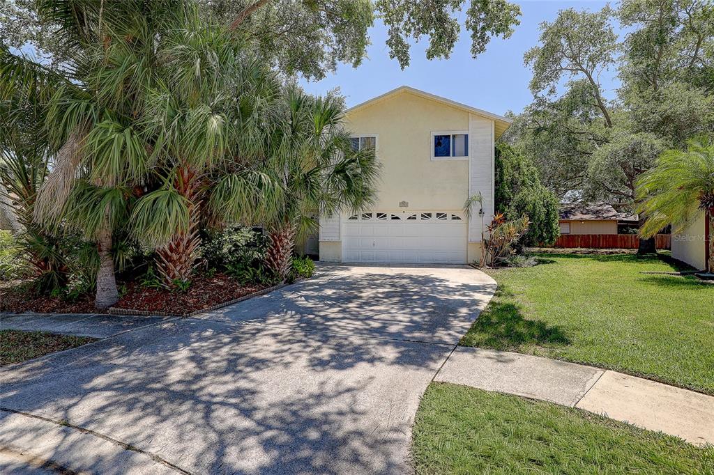 A two-story house with a yellow exterior, a white garage door, and a concrete driveway — 4505 33RD AVENUE W, BRADENTON, FL