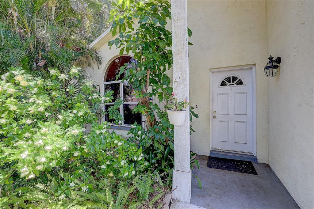 A white front door with a small arched window sits beside a large arched window — 4505 33RD AVENUE W, BRADENTON, FL