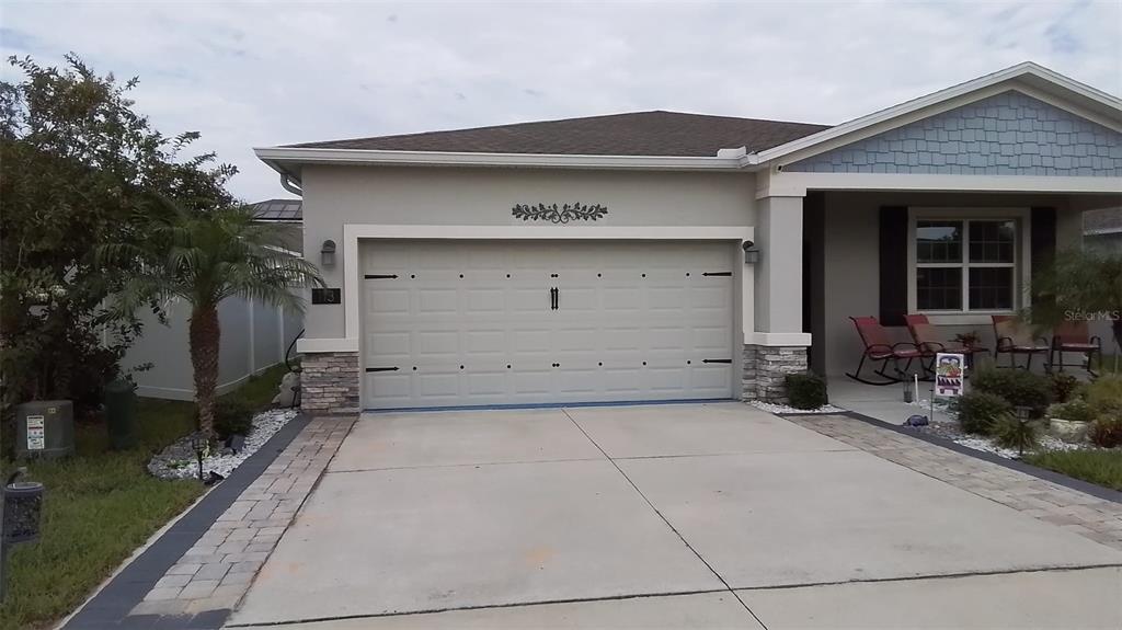 A single-story house features a two-car garage, a paved driveway, and a covered front porch — 113 TAFT DRIVE, DAVENPORT, FL