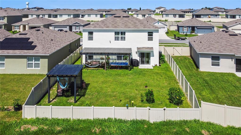 An aerial view of a two-story house with a fenced backyard, patio, and detached pergola — 270 MEADOWBROOK BOULEVARD, WINTER HAVEN, FL