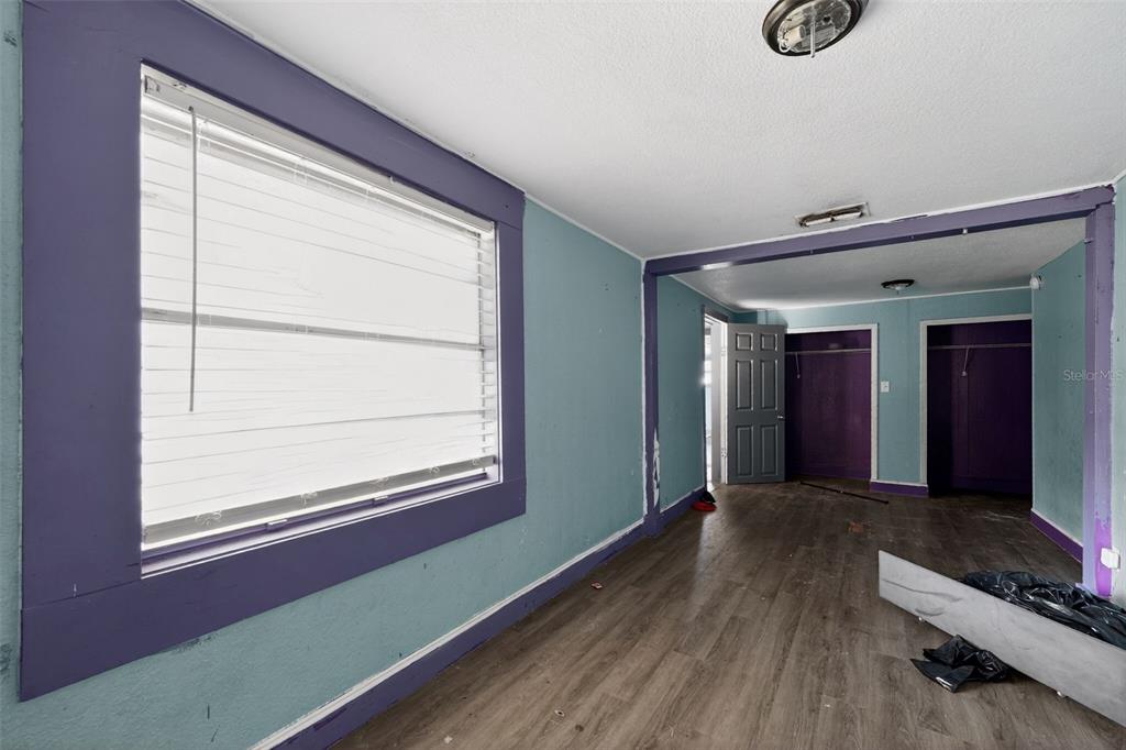 A single-story house with light blue siding, a metal roof, and a front porch — 108 EARL AVENUE, AUBURNDALE, FL