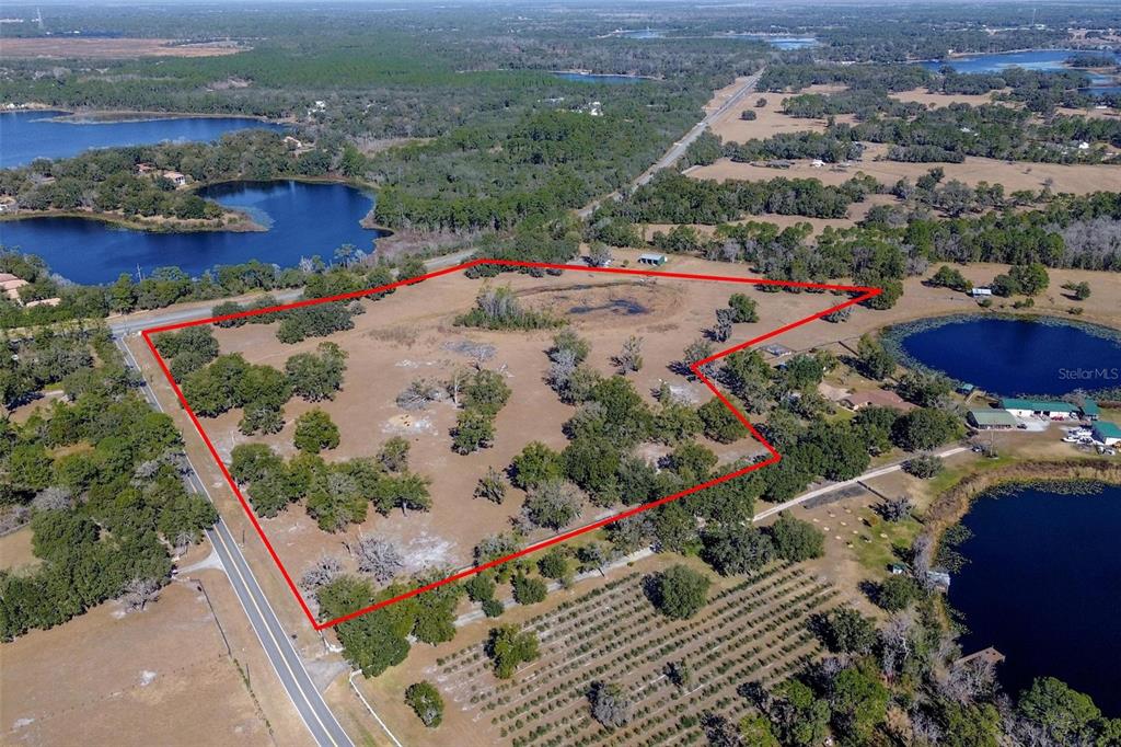 An aerial view shows a large, undeveloped parcel of land outlined in red — CARTER ROAD, DELAND, FL