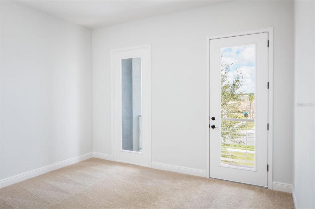 A room with beige carpet, white walls, a glass-paneled door, and a tall narrow window — 6677 WAKE STREET, ST CLOUD, FL
