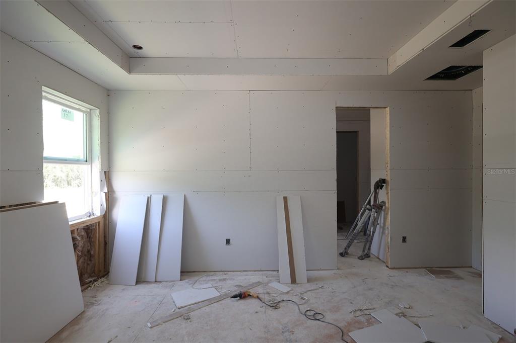 An unfinished room with drywall, a window, and a doorway under construction — 2879 SWEETGRASS LANE, ZELLWOOD, FL