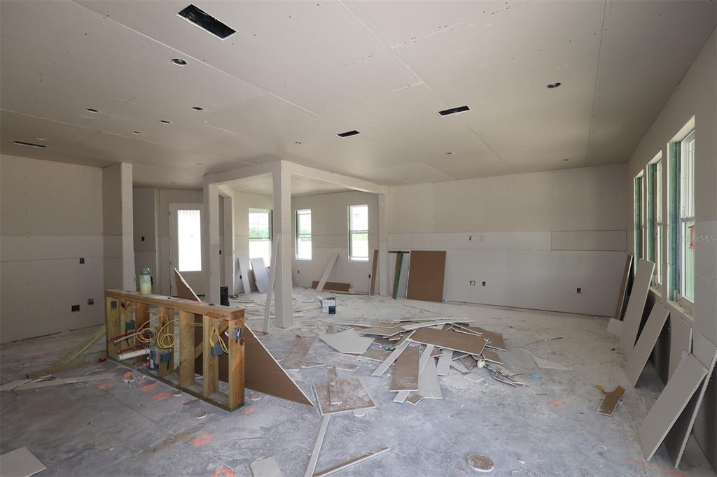 An unfinished room with drywall, exposed framing, and construction debris on the floor — 2879 SWEETGRASS LANE, ZELLWOOD, FL