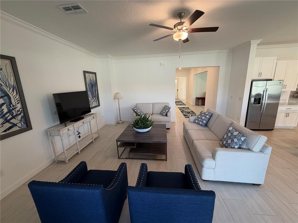 A living room features light tile floors, a sofa, two armchairs, and a coffee table — 17165 SCUBA CREST STREET, WIMAUMA, FL