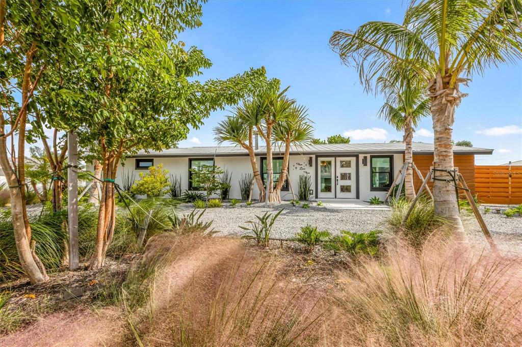 A single-story house with a white exterior, flat roof, and palm trees in the front yard — 505 65TH STREET, HOLMES BEACH, FL