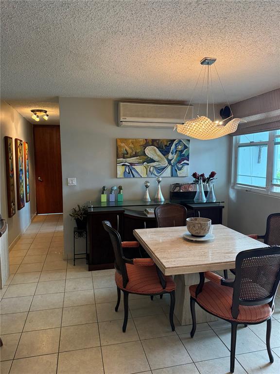 A dining room features a square stone table, cane-back chairs, and a modern pendant light — 155 CARRAZO UNIT 8D, GUAYNABO, PR